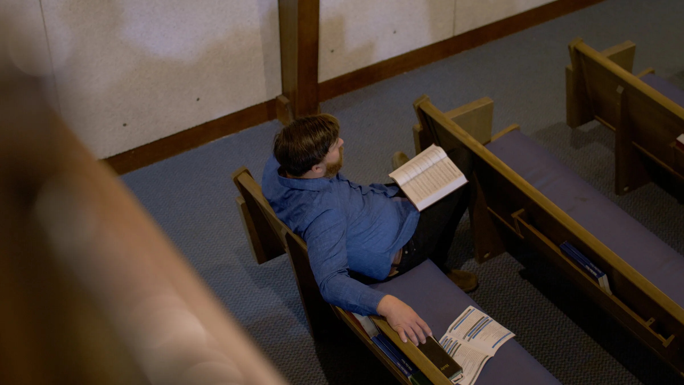 A worshipper reading in the pews