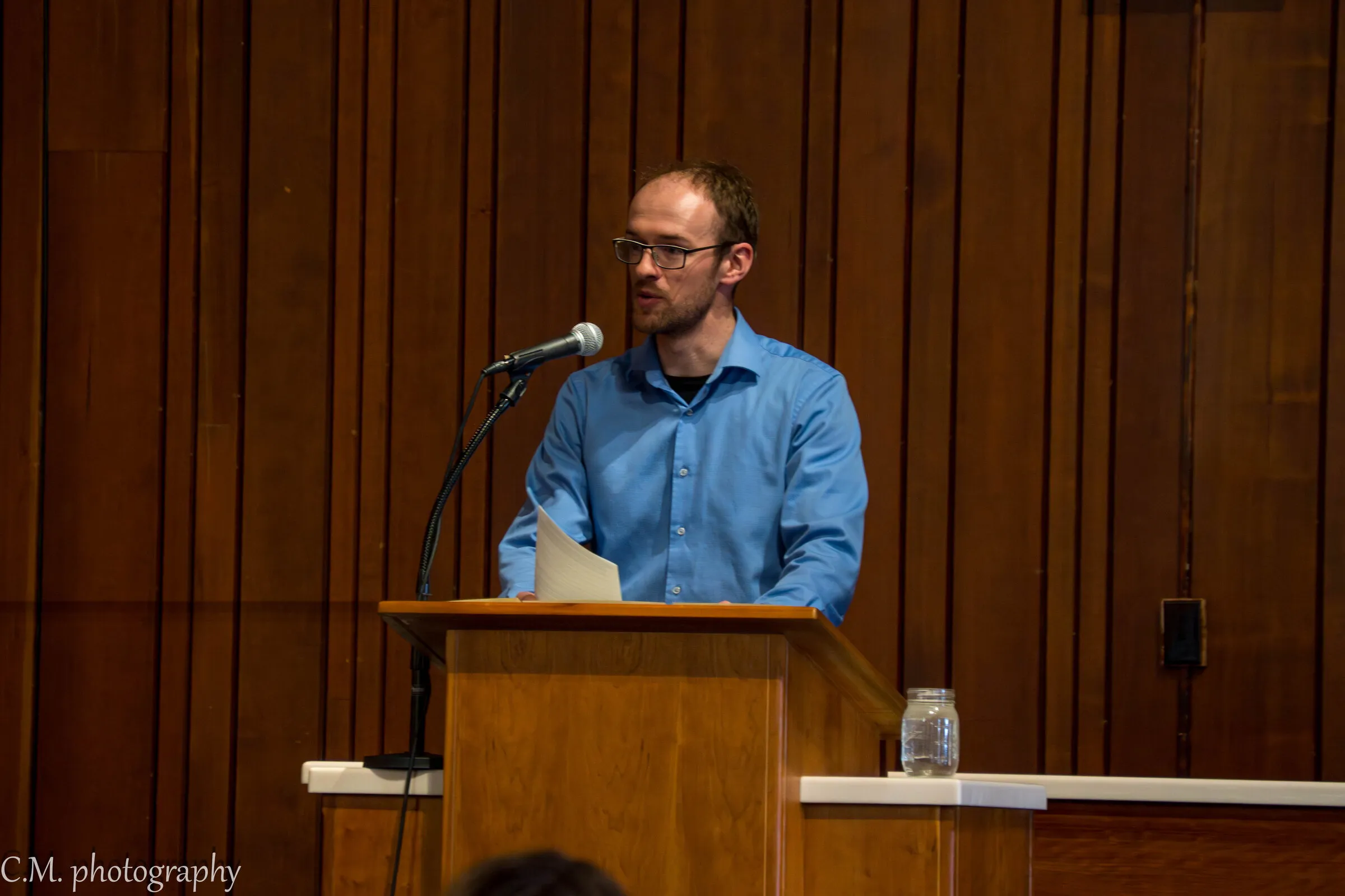 A man reading Scripture from the lectern