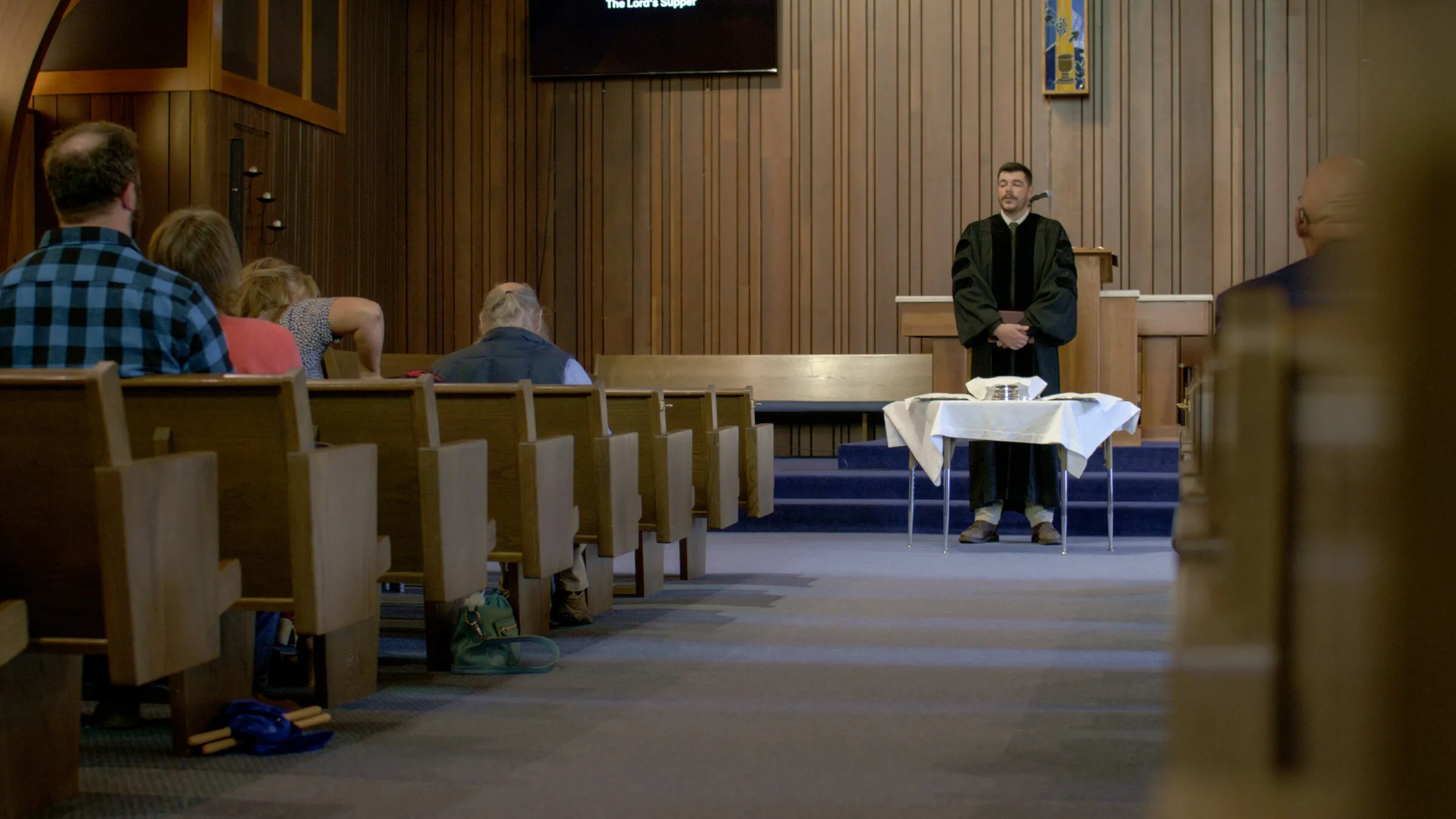 The minister leading worship from the front of the sanctuary