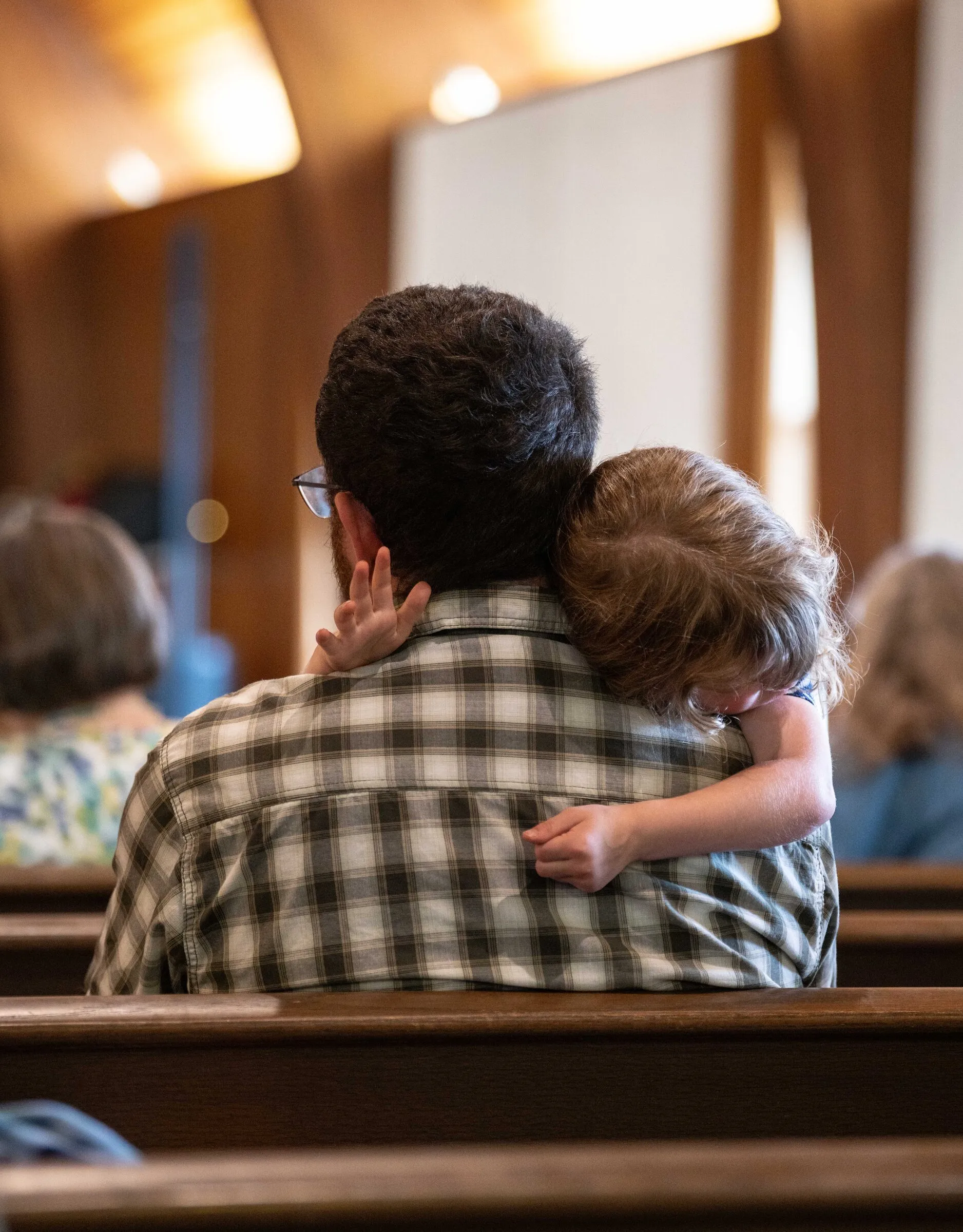 A father holding his young son during the service